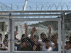 Young migrants and refugees stand at a fence of the Moria detention centre during a visit of Pope Francis in Mytilene, on 16 April, 2016. (AFP/File)