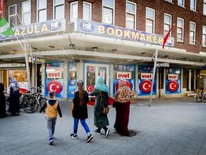 People walk past Turkey's upcoming referendum campaign posters reading "Yes" in Turkish, on the facade of a building in Rotterdam on March 25, 2017. (AFP/Remko de Waal)