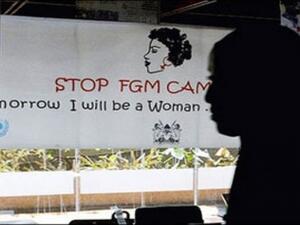 A woman walks past a poster from a campaign to stop FGM in Egypt. (AFP/File)