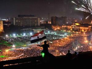 Egyptians wave the national flag on a building rooftop on July 7, 2013 as hundreds of thousands flood Egypt's landmark Tahrir square to demontrate against ousted President Mohammed Morsi and in support of the Egyptian Army in Cairo (Mohamed el-Shahed / AFP)