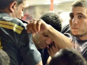 A student suffering from food poisoning is helped into an ambulance (AFP Photo/ Mohammed Al Shahed)