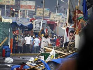 EGYPT, Cairo : A supporter of Egypt's ousted president Mohamed Morsi (portrait) shouts slogans as Egyptian security forces move in to disperse the pro-Islamist protesters by force in a huge protest camp near Rabaa al-Adawiya mosque in eastern Cairo on August 14, 2013. AFP PHOTO /MOHAMMED ABDEL MONEIM