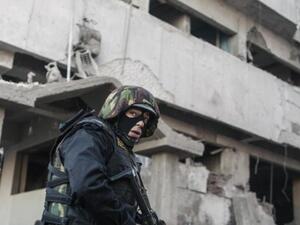  A member of the Egyptian security forces stands in front of the damaged police building following a powerful car bomb explosion in the Egyptian city of Mansura earlier this week. [AFP]