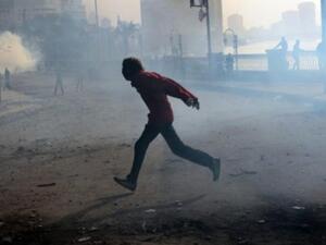 متظاهر يهرب من دخان القنابل المسيلة للدموع بالقرب من ميدان التحرير بالقاهرة/ا.ف.ب