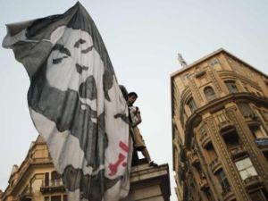 متظاهر ضد الحكومة يرفع علما كبيرا عليه صورة احد ضحايا التظاهرات الاخيرة في القاهرة/أ.ف.ب