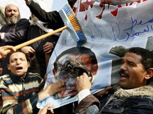 متظاهر يضرب صورة الرئيس مبارك بالحذاء /أ.ف.ب