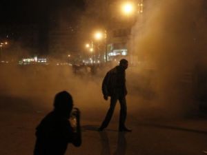 متظاهرون يهربون من دخان القنابل المسيلة للدموع في التحرير/الجمعة/أ.ف.ب