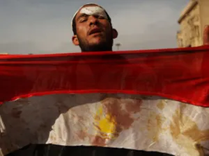 متظاهر يحمل علما ملطخا بالدماء
