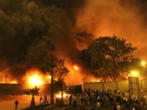 محتجون يقفون حول مقر الحزب الوطني الحاكم في القاهرة والذي اشتعلت فيه النيران