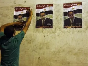 مصري يضعع ملصقات انتخابية لنجل الرئيس المصري جمال مبارك
