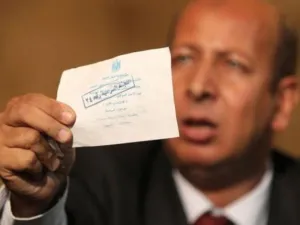 احد اعضاء حزب الوفد يحمل صوتا يقول حزبه انه مزور خلال مؤتمر صحافي في مقر الحزب في القاهرة الخميس