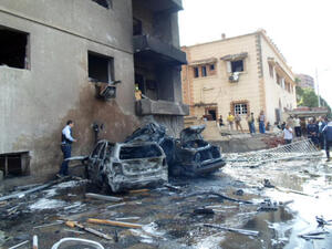 People look at burnt vehicles after a car bomb attack outside a military intelligence building that wounded four people on October 19, 2013 in Egypt's canal city of Ismailia. (Image credit: AFP)