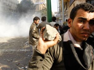 شاب يحمل حجارة خلال المصادمات في محيط ميدان التحرير