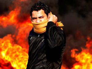 متظاهر يقف امام نيران مشتعلة في العاصمة المصرية