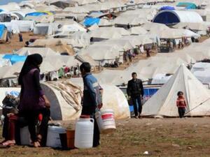 Syrian refugees filling their buckets at Atmeh refugee camp, in the northern Syrian province of Idlib, Syria, Apr. 5, 2013. [Getty Images]
