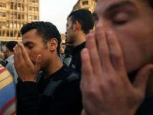 شبان مصريون في ميدان التحرير يقراون الفاتحة امام نصب للقتلى في احداث مصر