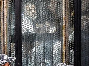 Essam el-Erian (R), one of the highest-ranking leaders of Egypt's banned Muslim Brotherhood, is seen alongside other members of the group inside a glass dock during their trial in the capital Cairo on July 28, 2018. (AFP Photo)