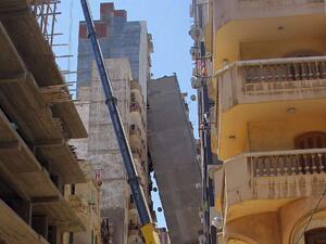 A high-rise apartment block in Egypt's second city Alexandria toppled across a street and was being propped up by another tall building on June 1, 2017. (AFP)