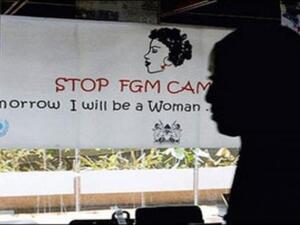 A woman walks past a poster from a campaign to stop FGM in Egypt. (AFP/File)