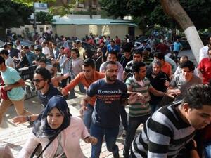 Egyptian protesters run for cover from tear gas fired by riot police during a Cairo demonstration against the handing over of two Red Sea islands to Saudi Arabia, April 25, 2016. (AFP/Mohamed el-Shahed)