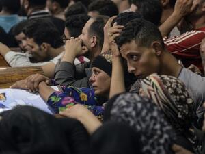 Relatives of killed Coptic Christians grieve by the coffins during the funeral at Abu Garnous Cathedral in the north Minya town of Maghagha, on May 26, 2017 (Mohamed El-Shahed/AFP)