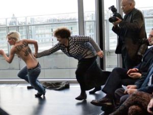 احدى عضوات جماعة فيمن تحاول اقتحام محاضرة للرئيس التونسي في باريس تضامنا مع "امينة"/أ.ف.ب