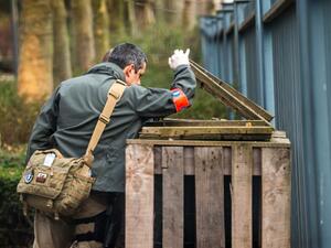 A forensic policeman examines a trashcan near the Molenbeek subway station, looking for clues. (AFP/Philippe Huguen)