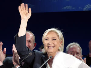 The audience sport red and blue National Front buttons and blue roses. The venue is a sea of French flags.(AFP) 