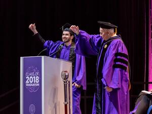 Fouad Hassan, the student speaker at NU-Q’s graduation ceremony, and Dean Everette E. Dennis perform the Northwestern Wildcat cheer.