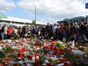 People mourn at a memorial on July 24, 2016 in front of the Olympia Einkaufszentrum shopping center in Munich, Germany, where an 18-year-old German-Iranian student shot and killed nine people. (AFP/Christof Stache)