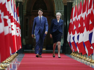 Canadian Prime Minister Justin Trudeau and British Prime Minister Theresa May walk down the Hall of Honour in Ottawa, Ontario (AFP/File Photo)	