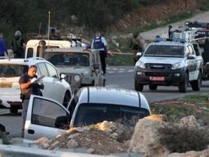 Israeli forces check cars outside of the Otniel settlement after a similar attack. (AFP/File)