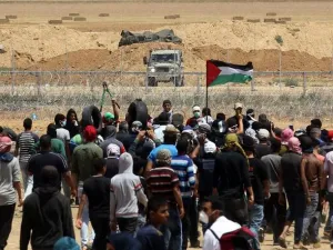 Palestinian demonstrators gesture towards Israeli forces during clashes along the Gaza border (AFP photo)