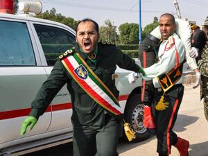 An Iranian soldier carrying an injured comrade at the scene of an attack on a military parade in Ahvaz on September 22. (AFP/File)