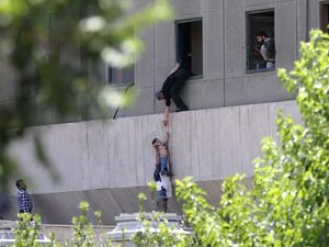 Iranian policemen evacuate a child from the parliament building in Tehran on June 7, 2017 during an attack on the complex. (Omid Vahabzadeh/Fars News/AFP)