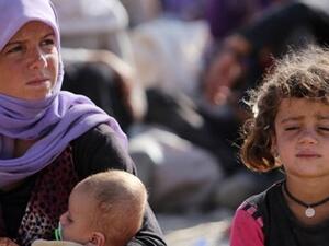 Yazidi Women in Iraq sit outside their camp. (AFP)