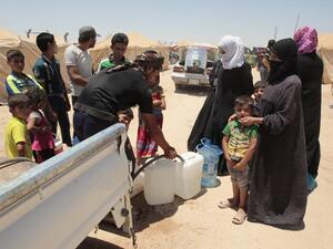 Iraqi families receive water at a camp for internally displaced people after fleeing Fallujah during the military operation to retake the city from Daesh. (AFP/File)