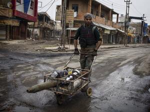 A Christian militia fighter from the Nineveh Plain Protection Units (NPU) pushes a trolley carrying a rocket in a street in Qaraqosh, some 30 kilometres east of Mosul on December 20, 2016. (AFP/JM Lopez)
