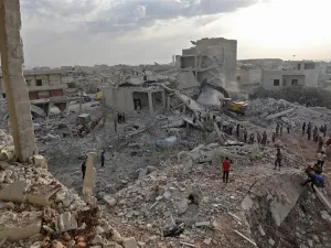 Syrians gather amidst destruction in Zardana, in the mostly rebel-held northern Syrian Idlib province [AFP] 
