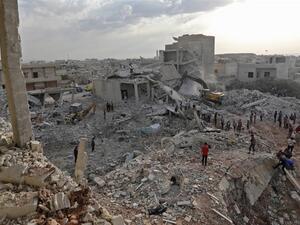 Syrians gather amidst destruction in Zardana, in the mostly rebel-held northern Syrian Idlib province [AFP] 
