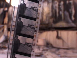 Strip of black and white movie film, out of focus bombed Baghdad Cinema Studios. (Shutterstock)