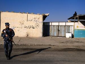 An Iraqi policeman stands guard as the Iraqi army search for booby-trapped buildings in eastern Mosul on 16 January. (AFP/File)