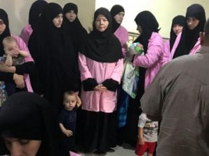 Baghdad's Central Criminal Court shows women who have been sentenced to life in prison on grounds of joining ISIS standing with their children in a hallway. (Ammar Karim / AFP)