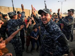 Members of the Iraqi federal police dance with children during a celebration in the Old City of Mosul, where the gruelling battle to retake Iraq's second city from Islamic State (IS) group fighters is now nearing its end, on July 2, 2017. (AHMAD AL-RUBAYE / AFP)