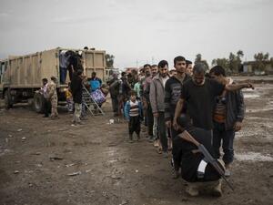 Displaced Iraqi men arrive at a processing center in western Mosul on April 14, 2017, before they are transported to refugee camps. (AFP/Christophe Simon)