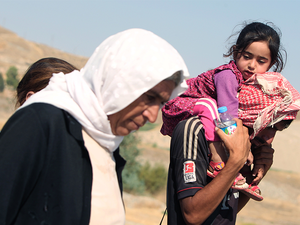 Displaced Iraqi families from the Yazidi community cross the Iraqi-Syrian border at the Fishkhabur crossing, in northern Iraq, on August 13, 2014.(AFP/Ahmad Al-Rubaye)