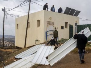 Israeli settlers block the entrance to the the settlement outpost of Amona, in the Israeli-occupied West Bank. (AFP/File)