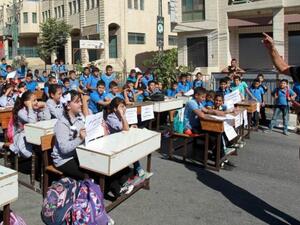 A Palestinian teacher gives a class during a protest by children and teachers against the reduction of educational programs in the West Bank. (AFP/File)