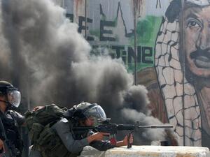 Israeli soldiers attack Palestinian protestors at a checkpoint outside occupied Jerusalem (AFP)