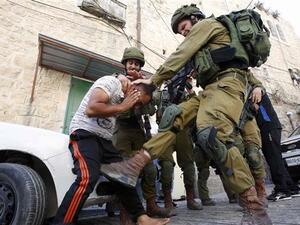 An Israeli soldier kicks a Palestinian man as troops try to arrest him in the southern West Bank city of Hebron. (AFP/ File)